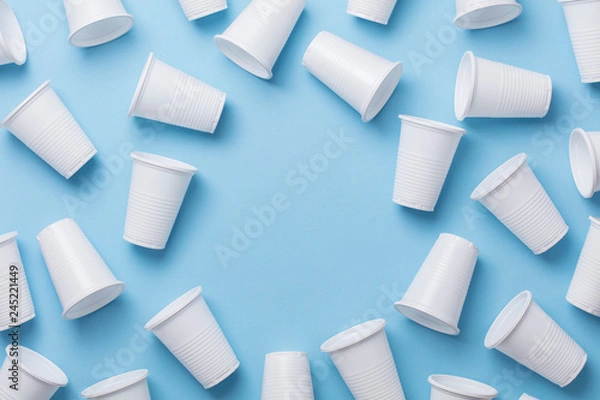 Fototapeta Single use white plastic cups on a blue background