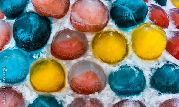 Obraz Vividly colored ice balls in snow as a street decoration during winter holidays.