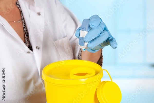 Obraz safely discarding used needle by using a needle container