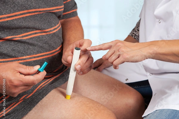 Obraz nurse instructs the use of an insulin pen. She shows the patiënt where to push the button