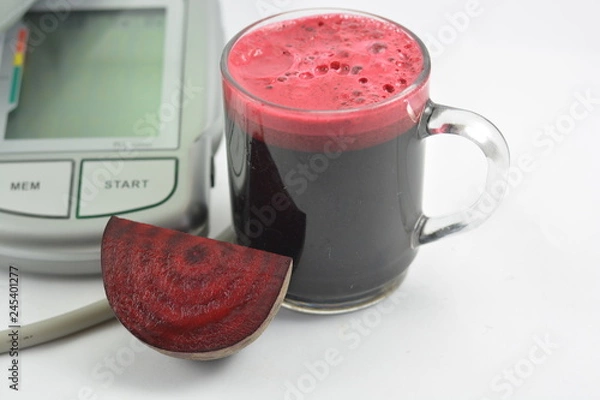 Fototapeta Beetroot juice with blood pressure machine on white background
