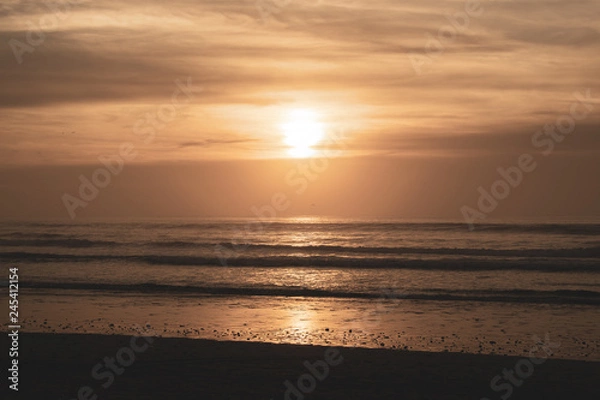 Fototapeta Sunset over main beach in Agadir Morocco showing silhouettes and reflections