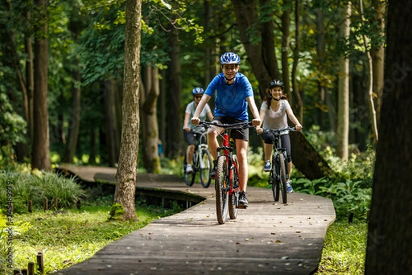 Fototapeta Healthy lifestyle - people riding bicycles in city park