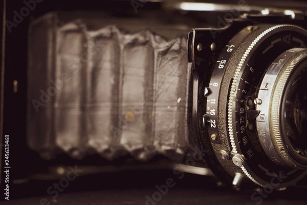 Fototapeta Bellows analogue camera on the black background and vintage or retro concept