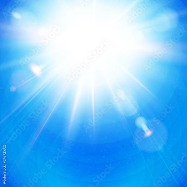 Fototapeta Bright Sunburst with radiating rays in a clear blue sky.