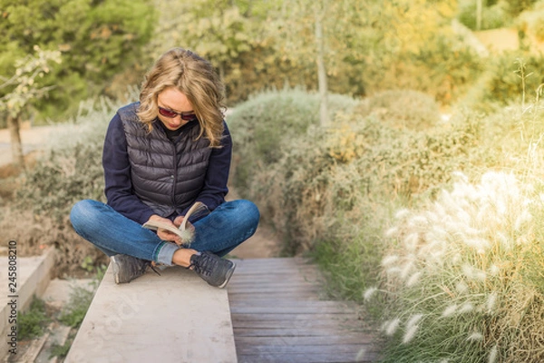 Obraz Stylish young woman outside the home reading a book