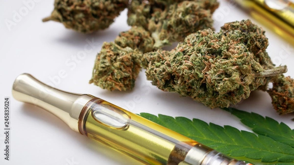 Obraz Skoncentrowany olej THC / CBD w kasecie zbliżenie z ziołem marihuany i szklaną rurą na białym tle