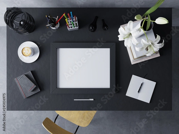 Fototapeta mock up design template to showcase artwork of empty poster in modern workspace in horizontal frame resting on a black polished table in straight top view