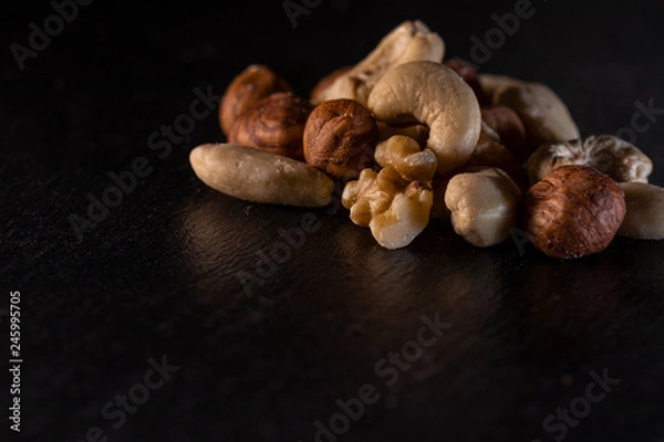 Obraz different nuts on a slate plate