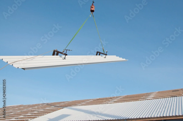 Fototapeta The process of installation of sandwich panels on a building site.