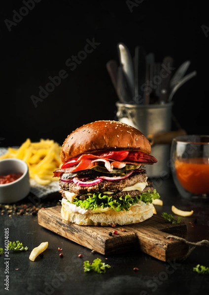 Fototapeta Tasty burger with bacon and chilli peppers with fries and ketchup