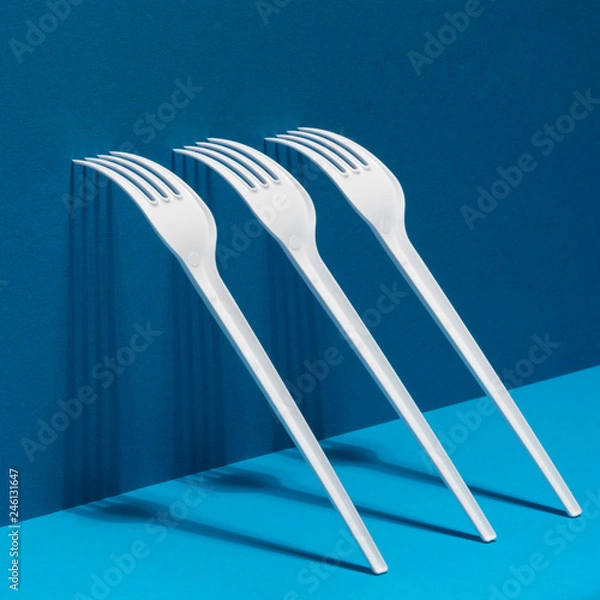 Obraz White forks with shadows on a mixed blue background