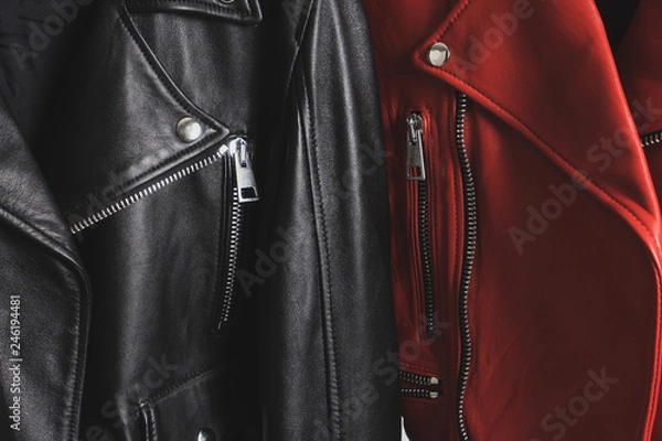 Fototapeta Red and black leather jackets with metallic zipper and buttons. Man and woman concept. Detailed closeup view.