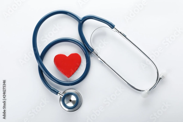 Fototapeta Stethoscope with red heart on white background, top view