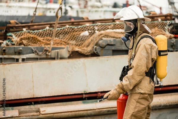 Obraz Firefighters in a sea port on a ship in undeveloped countries use teamwork on a training how to stop fire in a dangerous mission and protect the environment