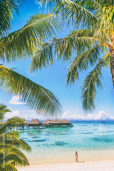 Fototapeta Tahiti luksusowy ośrodek turystyczny overwater bungalow hotel na Bora Bora idylliczne wakacje kobieta w raju pionowe tło z miejsca na kopię na palmach.