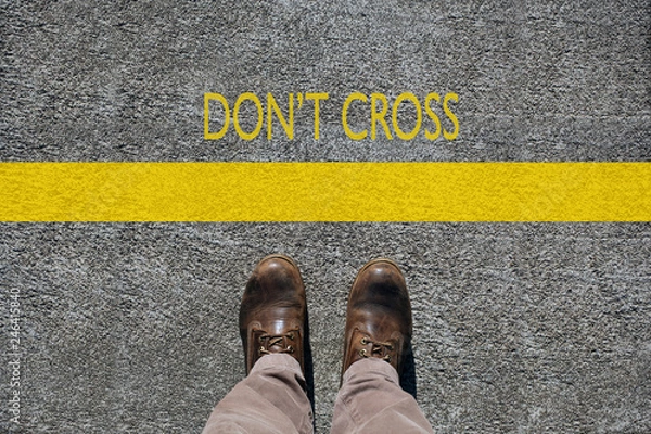 Fototapeta man's shoes view from above, words don't cross  and a  limit line
