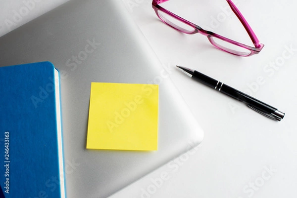 Fototapeta Notebook with black pen, Colorful notepads on the desk, Glasses on the desk with pen and cup of coffee, Computer keyboard with colorful note stick