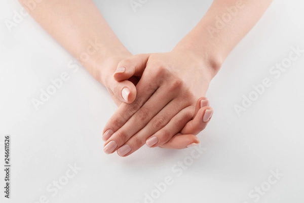 Fototapeta Partial view of female clanched hands on white background
