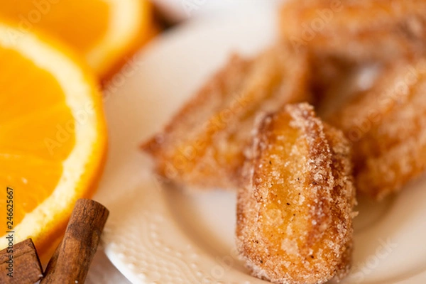 Obraz Spanish cuisine: churos and orange close-up on the table