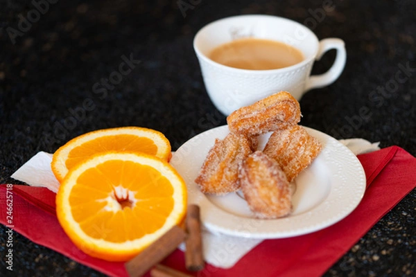 Obraz Spanish cuisine: churos and orange close-up on the table