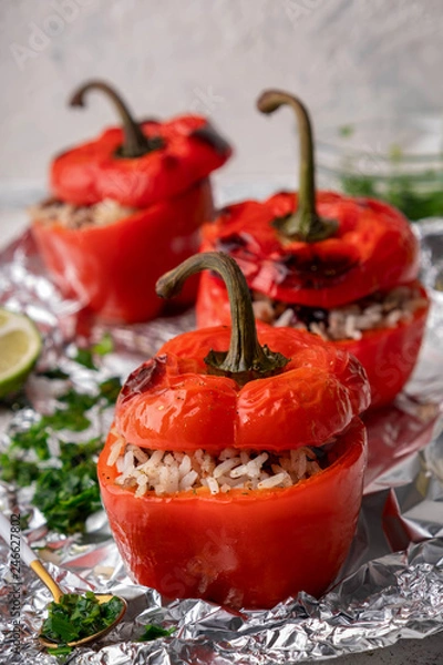 Fototapeta red bell peppers stuffed with meat, rice and cranberries, close-up