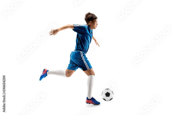 Fototapeta Young boy with soccer ball doing flying kick, isolated on white. football soccer players in motion on studio background. Fit jumping boy in action, jump, movement at game.