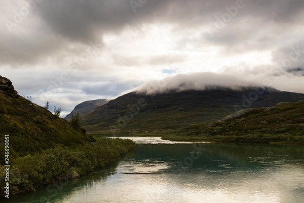 Fototapeta Mountain z chmurą na szczycie nad wioską Lapplander w Alesjaure w północnej Szwecji, jak widać podczas wędrówki Kungsleden (Kings Trail) późnym latem wczesnym rankiem przed wschodem słońca.