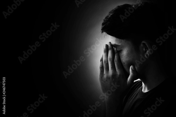 Fototapeta Depress and Hopeless boy praying in the dark in white tone