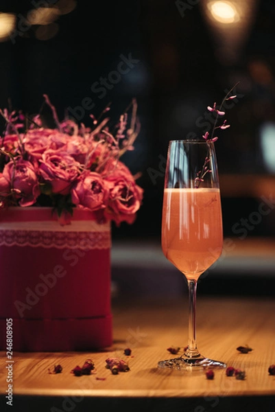 Fototapeta selective focus of pink alcoholic cocktail with flowers on dark background