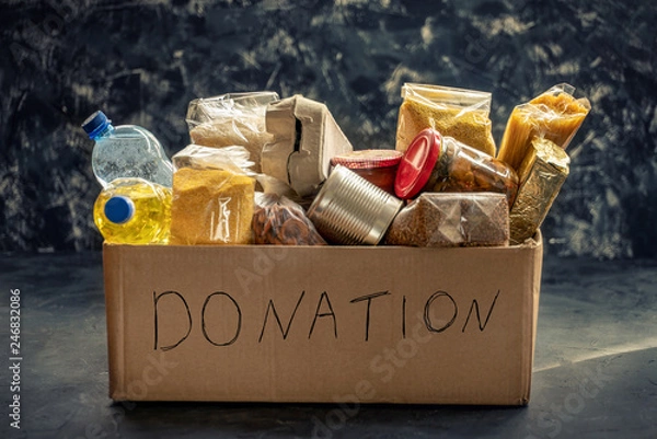 Fototapeta Donation box full of different products on dark background