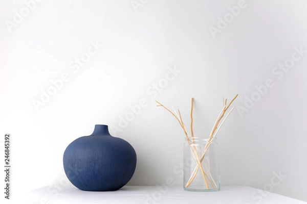 Obraz Blue round ceramic China vase and glass vase with wicker rattan reed on white table top on white background in natural light with copy space Minimal Asian interior styling.