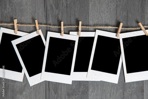 Obraz Blank vintage polaroid instant photos frame with empty space hanging on rope on wooden background. Copy and paste your photo