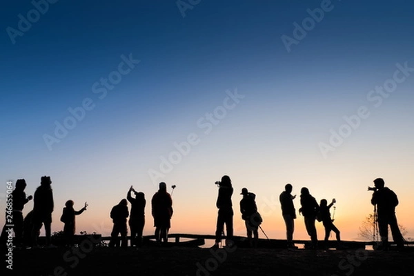 Fototapeta view Silhouette a group of tourists on top hill with colorful of yellow sun light background, sunrise at Doi Samur Dao, Sri Nan National Park, Nan, northern of Thailand.