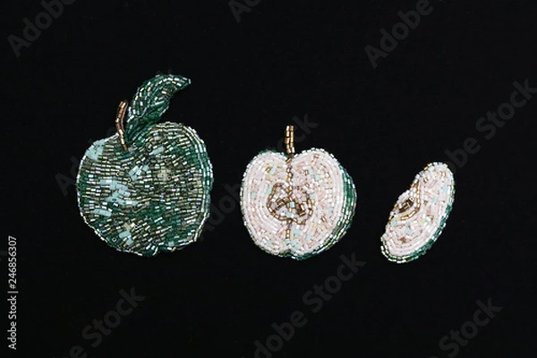 Fototapeta Three brooches in green apple form on black background 