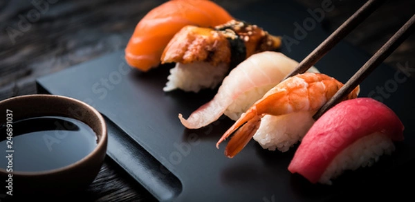 Fototapeta zamknąć sashimi sushi z pałeczkami i soi na czarnym tle