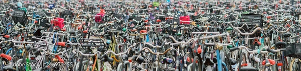 Fototapeta Panoramic view of a huge crowded public bicycle parking with many children seats.