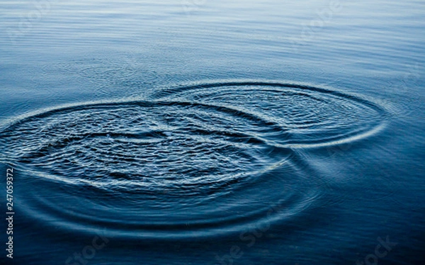 Fototapeta Ripples on sea texture pattern background. Round droplets of water over circles on pool water. Fresh water drop, whirl and splash. Laptop decorative wallpaper. Bright water rings affect the surface.