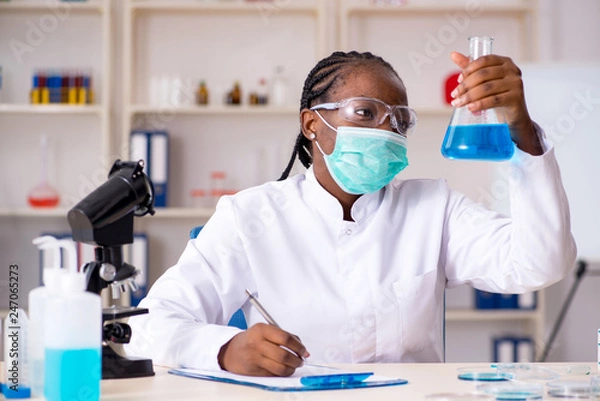 Fototapeta Young black chemist working in the lab 