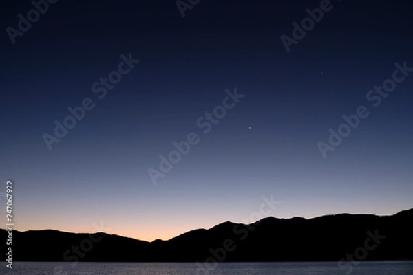 Fototapeta Night view with silhouetted mountains and stars at Lake Te Anau, South Island New Zealand