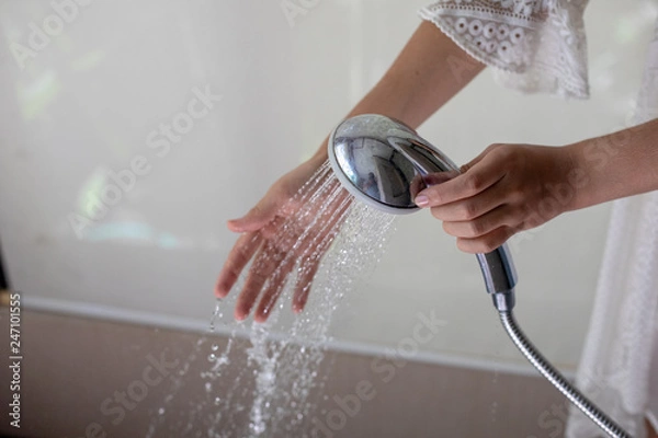 Fototapeta Close-up of a woman's hand checking water condition in the shower