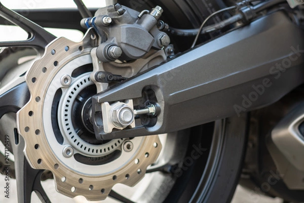 Obraz Szczegóły zbliżenia sportowego wyścigowego koła motocyklowego i układu hamulcowego ABS z aluminiowym wahaczem Tylna tarcza 220 mm z 1-tłoczkowym zaciskiem hamującym ABS w standardzie.