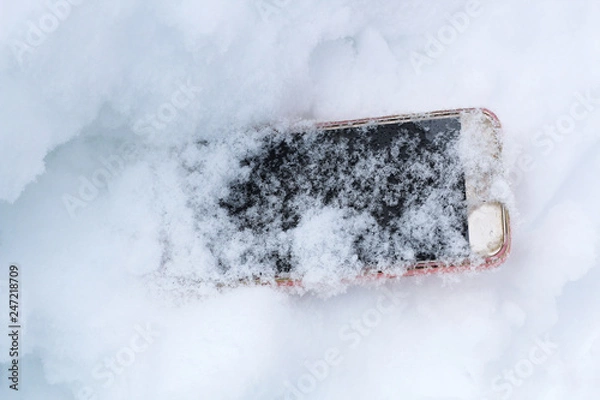 Fototapeta mobile phone accidentally fell out and got lost in the snow