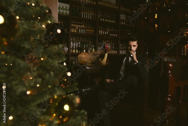 Obraz Attractive man wearing black tuxedo in whiskey bar.