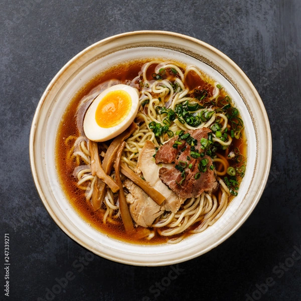 Fototapeta Ramen azjatycki makaron w bulionie z mięsem i marynowanym jajkiem Ajitama w misce na ciemnym tle