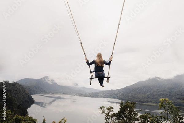 Obraz girl on a swing flies over a valley with lakes