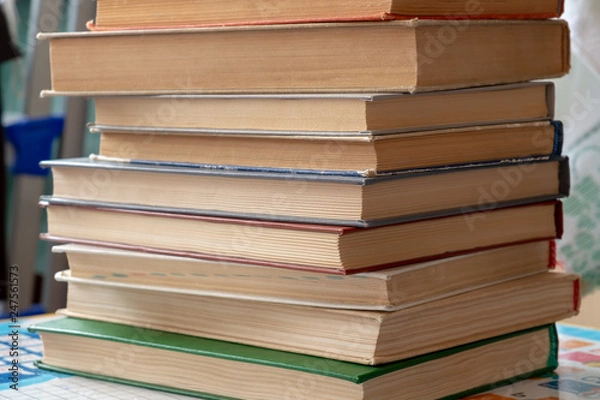 Fototapeta On the table is a stack of books with yellowed paper.
