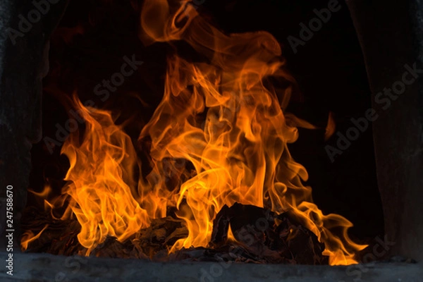 Fototapeta The flames are burning in the furnace. Blazing flames flare in the furnace.