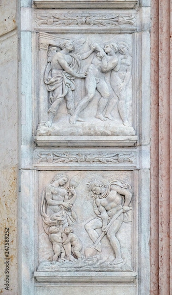 Fototapeta Expulsion from Paradise up, the work of Adam and Eve down, panel by Jacopo della Quercia on the central door of San Petronio Basilica in Bologna, Italy
