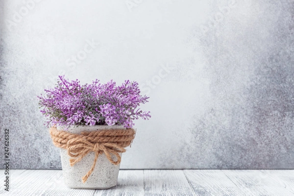 Obraz Small purple flowers in gray ceramic pots on stone background Rustic style